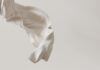 White fabric billows against a plain background.
