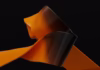 Orange and black ribbons float in a dark space.
